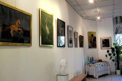 Galeriewand mit einem Pferdebild und einem geklöppelten Reiher