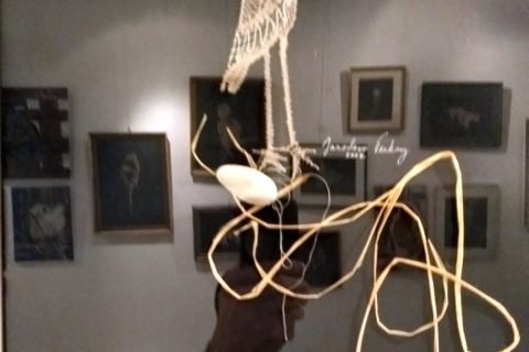 Gerahmtes Klöppelbild eines Reihers auf geschwungenen Linien