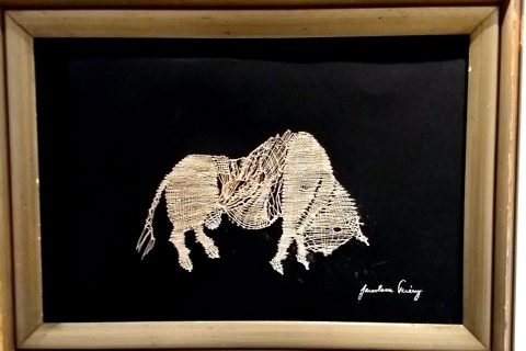 Gerahmtes Klöppelbild zweier Elefanten auf schwarzem Grund