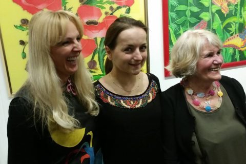 Drei Besucherinnen vor großformatigen Blumenbildern