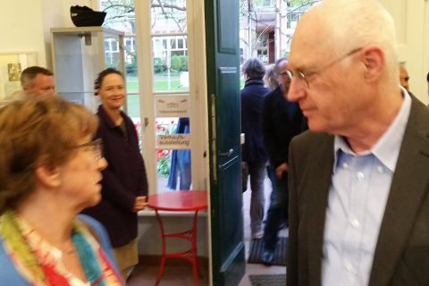 Zwei Gäste im Gespräch an der geöffneten Gartentür