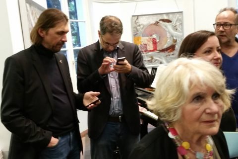 Besuchergruppe bei der Vernissage, ein Gast fotografiert