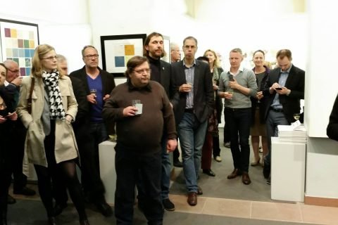 Besucher mit Getränken im Ausstellungsraum