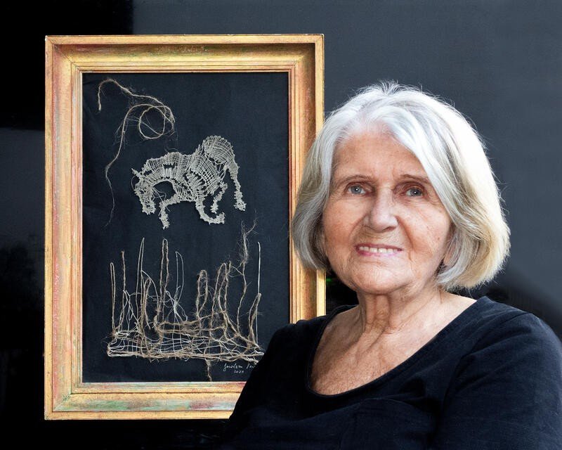 Jaroslava Perény mit Klöppelbild Jaroslava Perény neben ihrem gerahmten Klöppelbild eines Pferdes